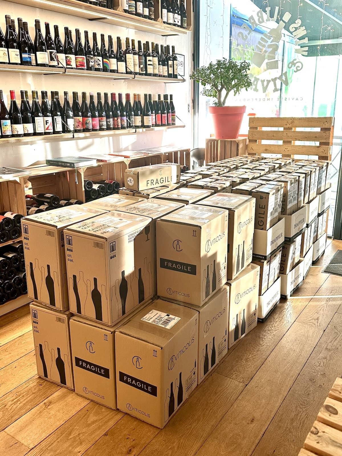 Colis de vin prêts à partir alignés dans la cave Maison Wino