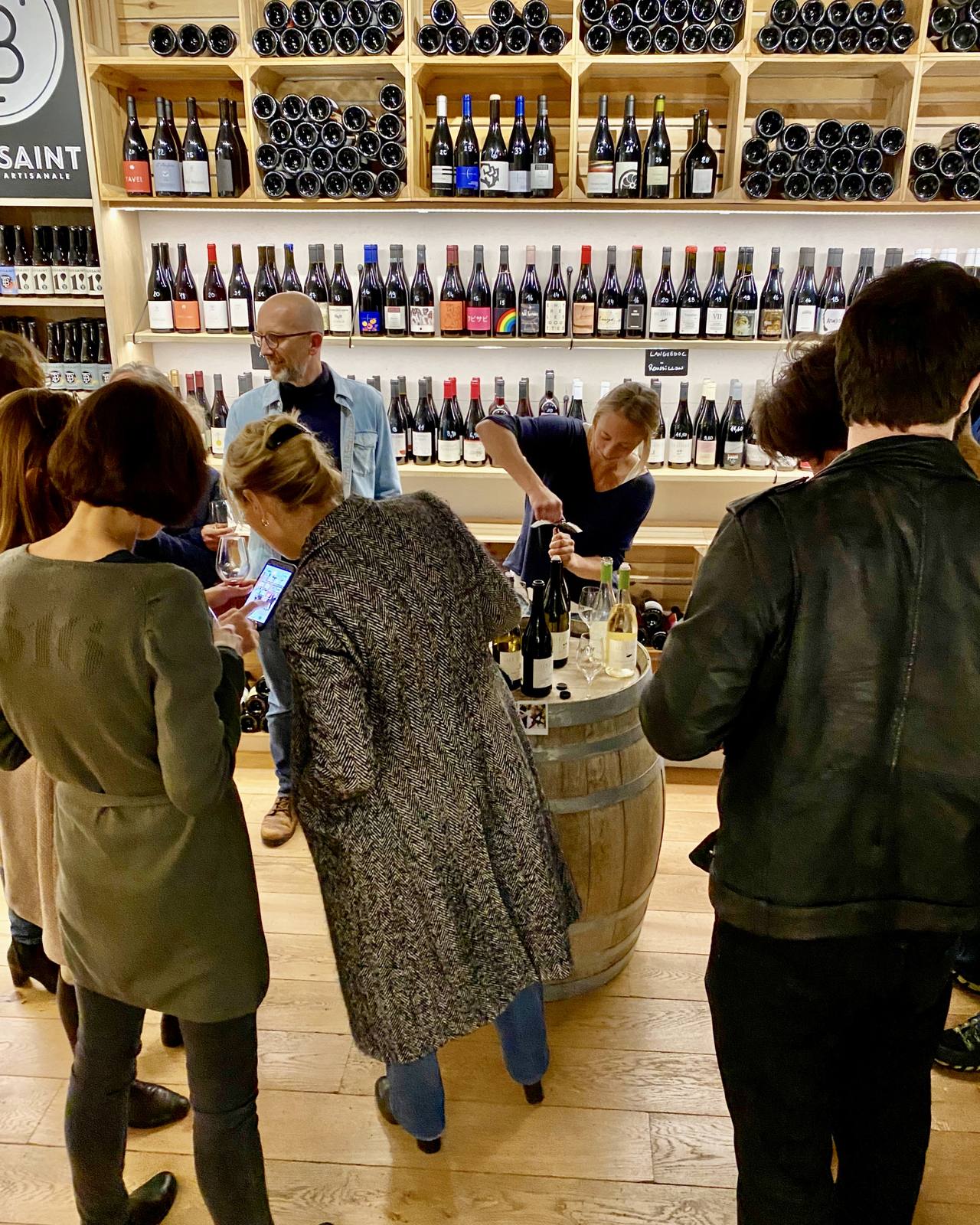 Vigneronne ouvrant une bouteille lors d'une dégustation à la cave Maison Wino